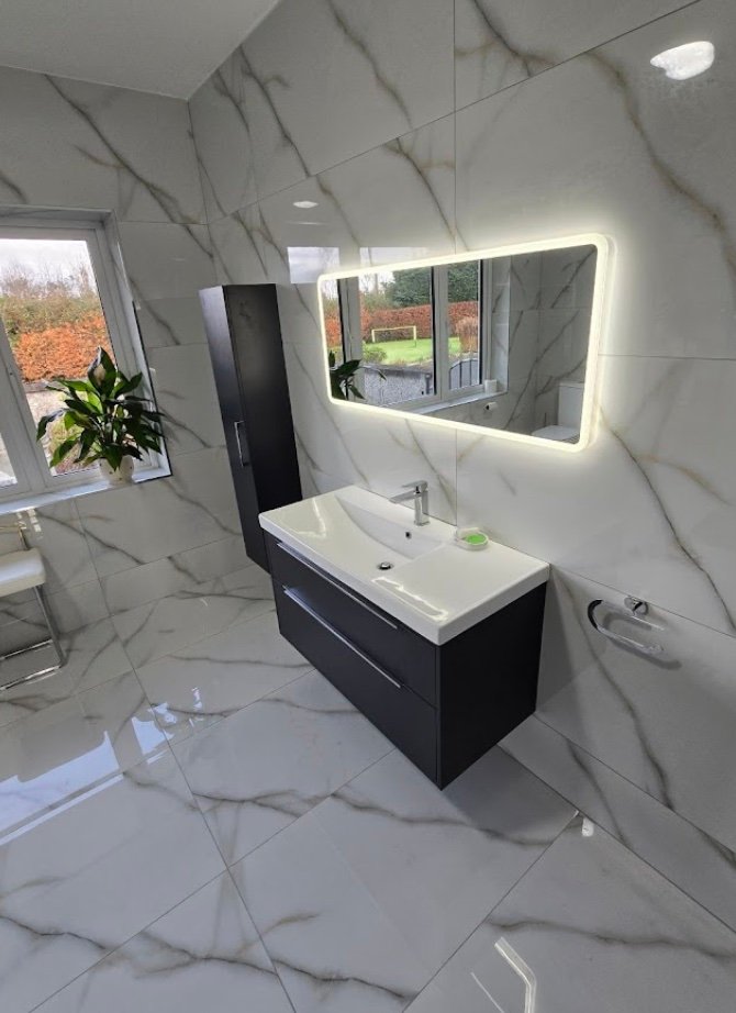 Marble bathroom with dark floating vanity and LED mirror