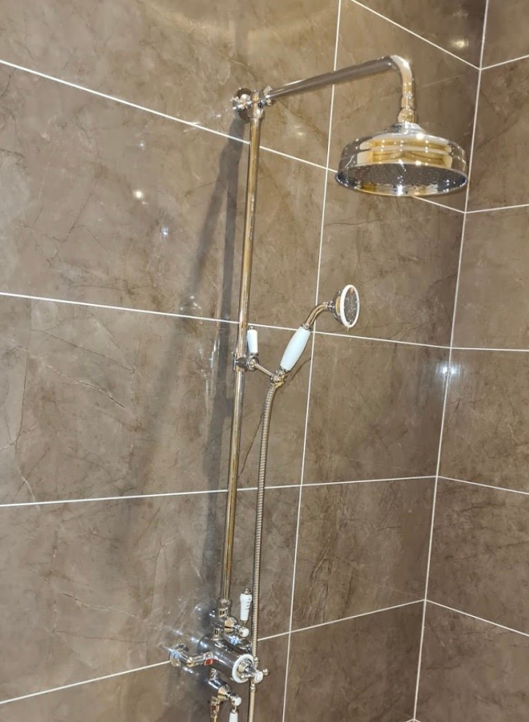 Luxury chrome rainfall shower head on marble tiles